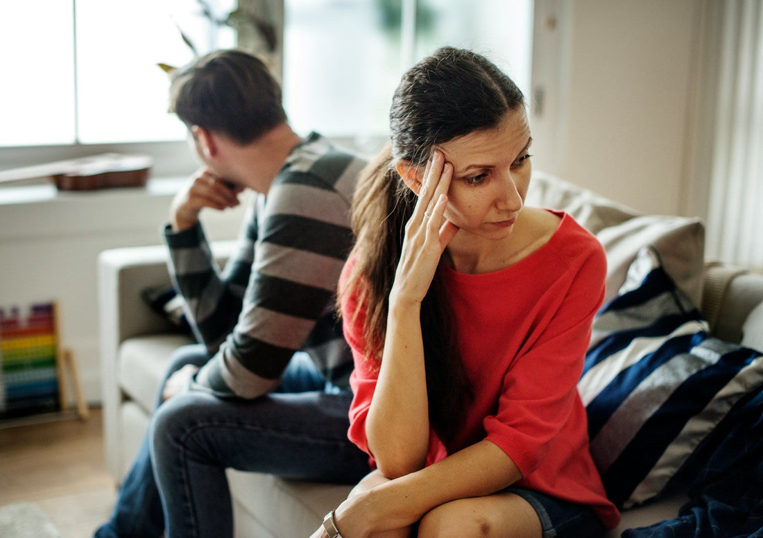 Couple sitting apart and looking emotionally distant, representing the slow fade in dating as interest and communication decline