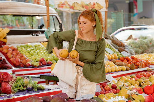 a woman in a green top is shopping for fruit filling her time as a single on a weekend