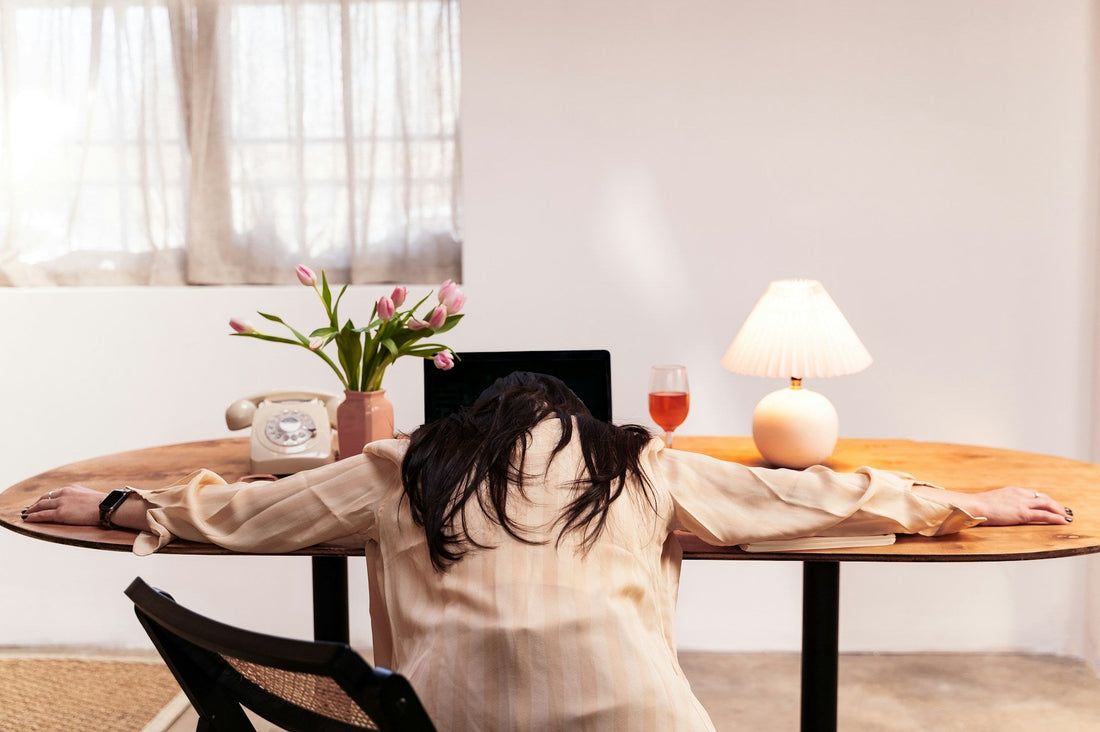 Exhausted woman slumped over a table, representing the emotional fatigue of always being the strong one in a relationship