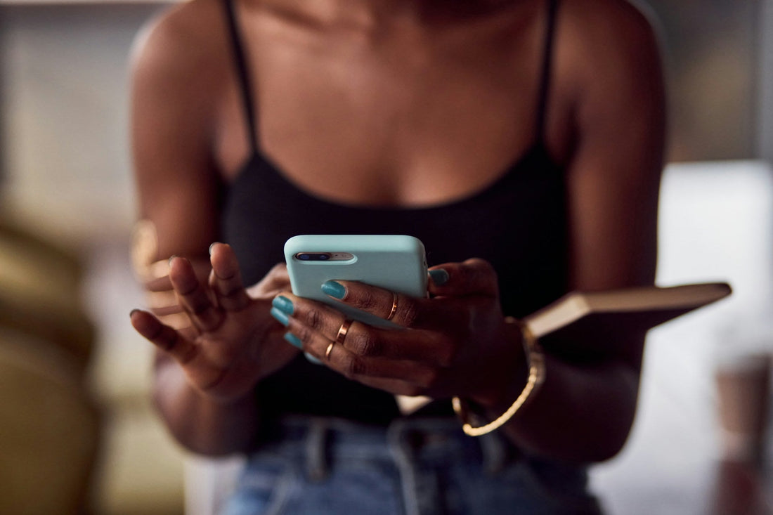 Woman checking her ex’s social media on her phone while struggling with post-breakup curiosity