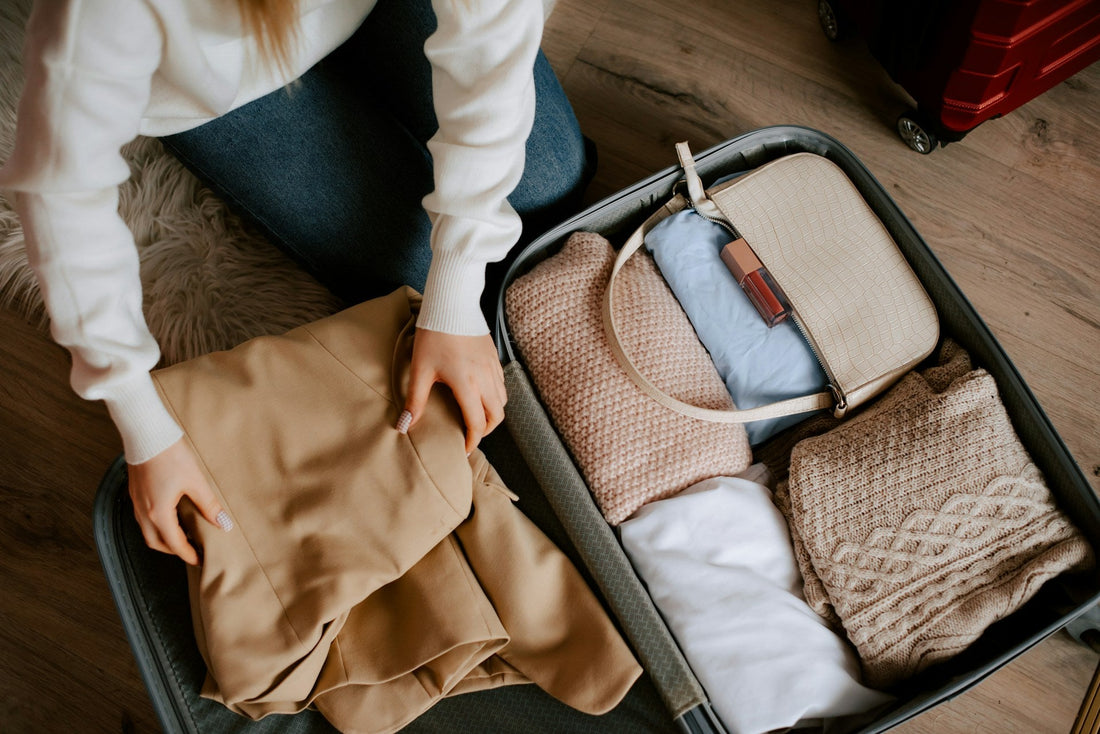 Woman packing clothes into an open suitcase, symbolizing guilt and uncertainty about leaving a narcissistic spouse.