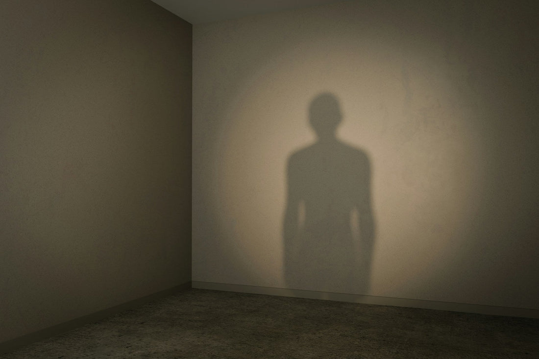 Shadow of a solitary person on a bare wall, symbolizing self-abandonment and losing yourself in a relationship.