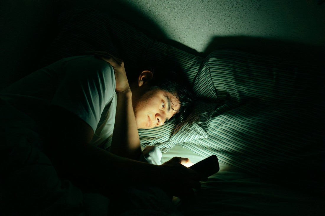 **SEO alt text:** `Person lying in bed at night looking at a phone, representing the intense uncertainty and message-checking common in a situationship`