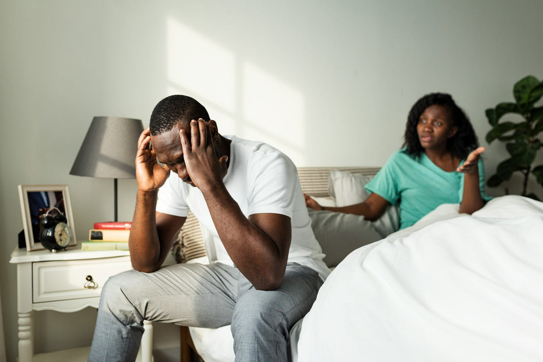 Man pulling away during an emotional conversation as his partner questions the growing distance in their relationship.