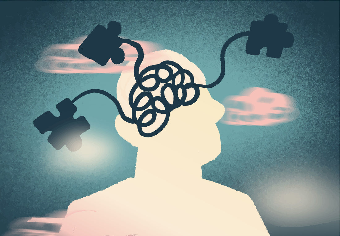 A stylized illustration of a person's head and shoulders in cream silhouette against a textured teal-blue background, with dark puzzle-piece shapes connected to the brain area and soft pink clouds.