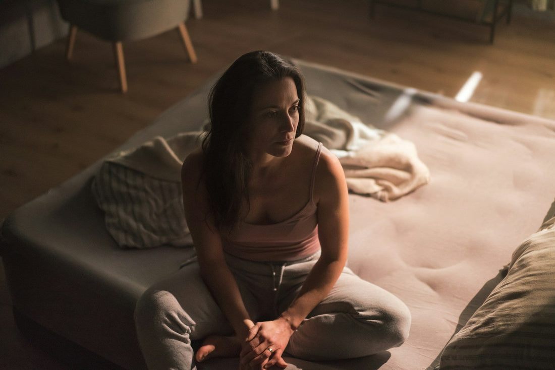Woman sitting alone on a bed, reflecting on repeated disrespect and whether to leave the relationship