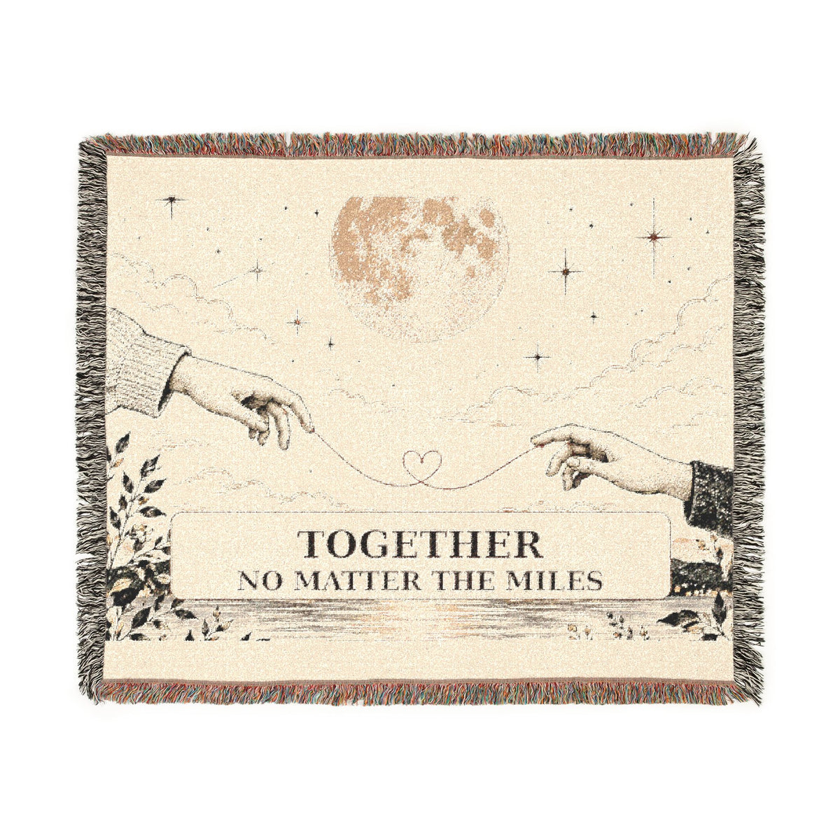 A square woven throw blanket with fringe edges, featuring an illustration of two hands reaching toward a string and a heart, with the text 'TOGETHER NO MATTER THE MILES' on a cream background with brown and black details.