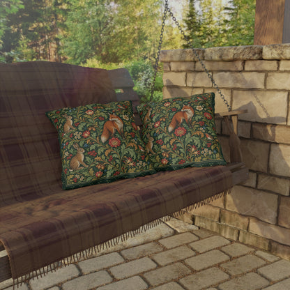 Two decorative throw pillows with a detailed woodland fox and floral pattern, resting on a brown plaid porch swing in front of a stone wall.