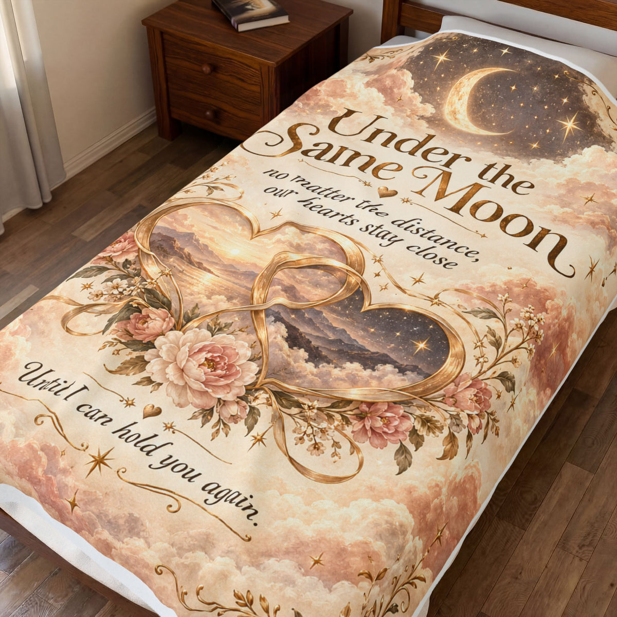 Under the Same Moon plush blanket with golden hearts and blush flowers displayed on a bed