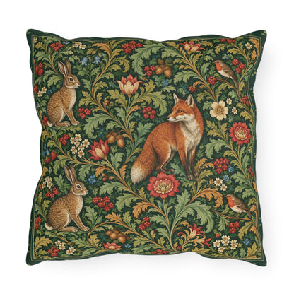 A square decorative throw pillow featuring a classic William Morris-style floral and animal tapestry pattern with a fox, rabbits, and birds on a dark green background.