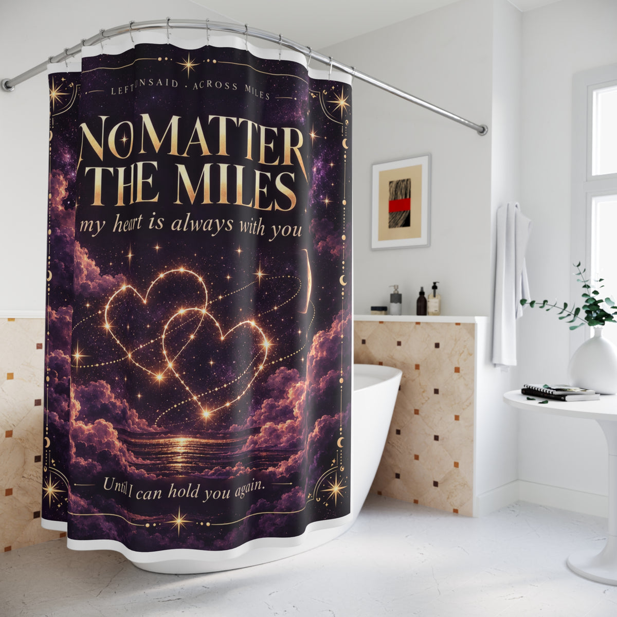 A shower curtain hanging in a bright modern bathroom. The curtain features a dark purple and black cosmic design with glowing gold stars, two interlocking heart-shaped constellations, and the text 'NO MATTER THE MILES my heart is always with you' and 'Until I can hold you again.