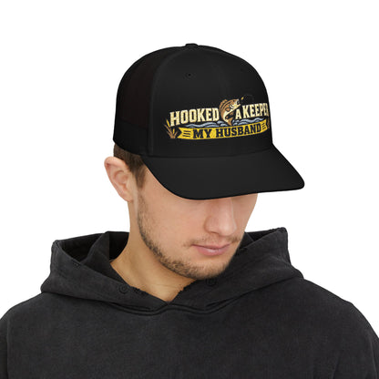 Person wearing a black cap with 'hooked a keeper'