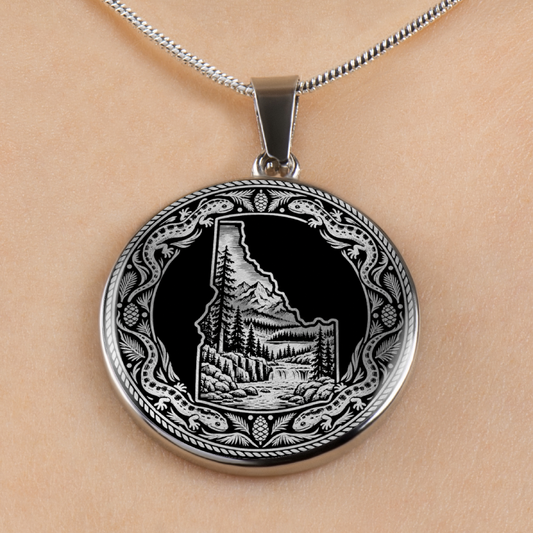 Silver Idaho wilderness necklace with Idaho state outline, mountain forest landscape, river and ornate salamander border