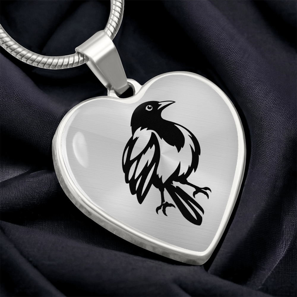 Close-up of heart-shaped magpie pendant with black and white illustration