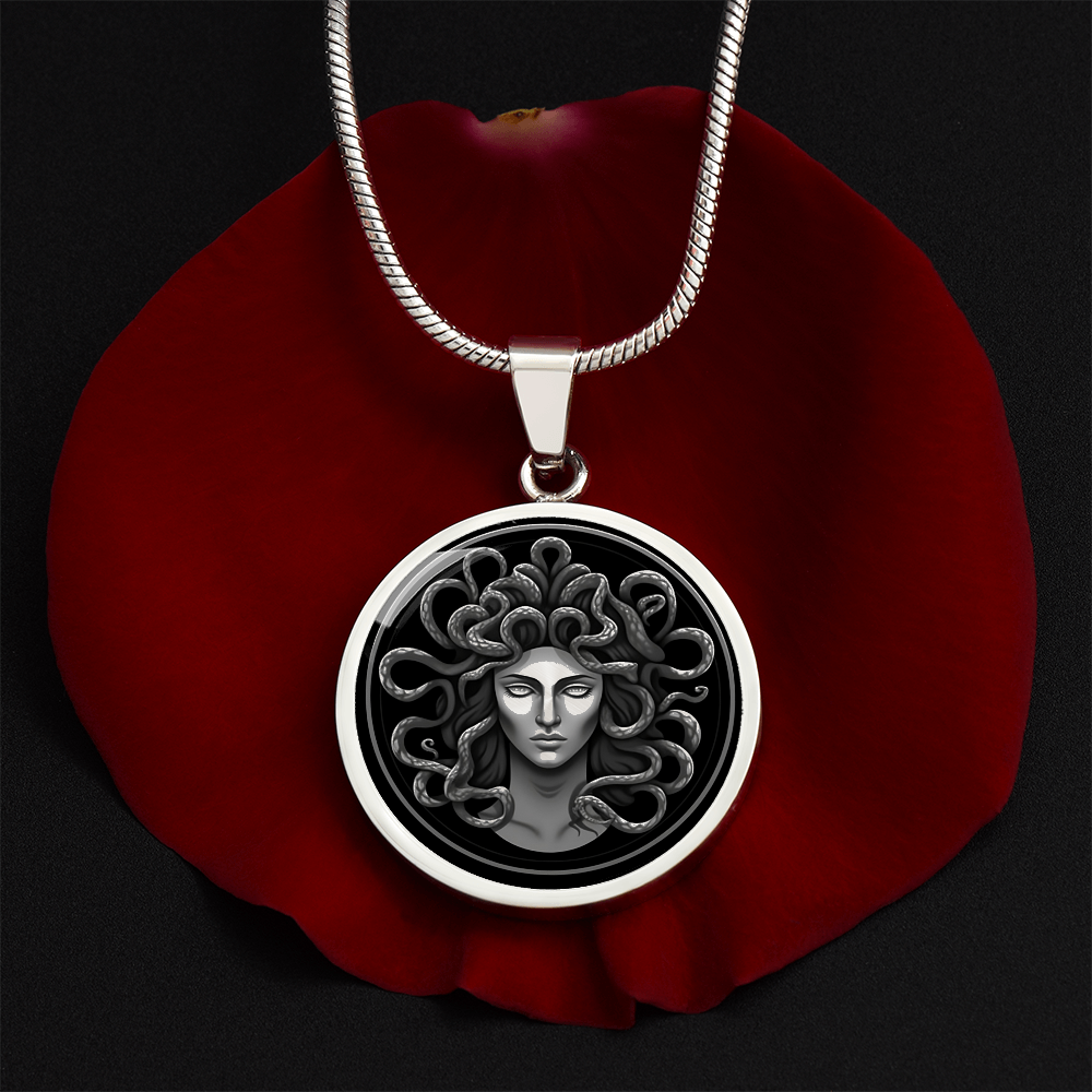 Medusa necklace with silver-grey female Gorgon face surrounded by coiling snakes on a black circular pendant.