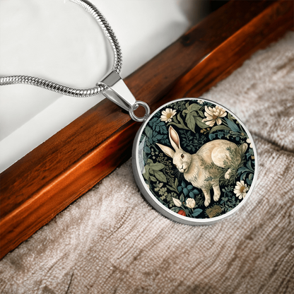 Silver Botanical rabbit necklace featuring a cream-colored bunny surrounded by ivory daisies and sage-green foliage on a dark round pendant.