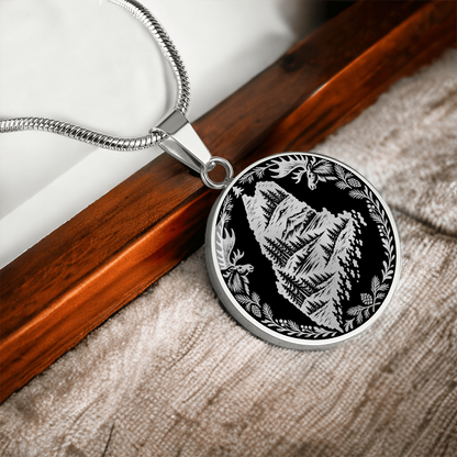 Silver Maine moose necklace featuring Maine state outline with mountain forest landscape, two moose and pinecone woodland border