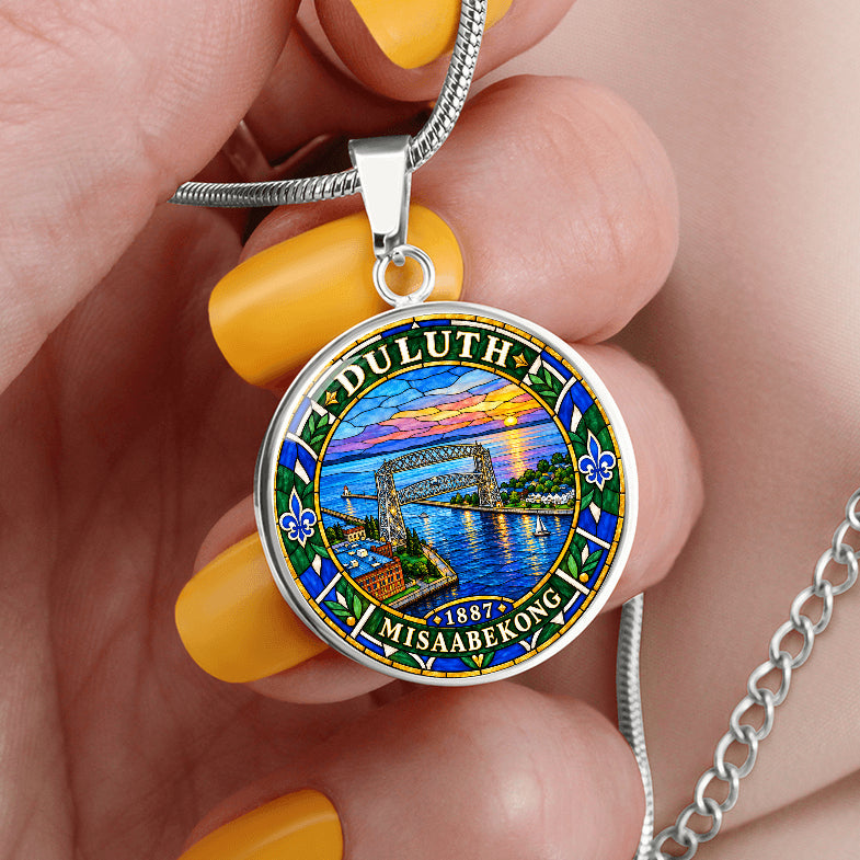 Silver Duluth Minnesota necklace featuring colorful stained-glass artwork of the Aerial Lift Bridge, Lake Superior, sunset sky and ornamental border