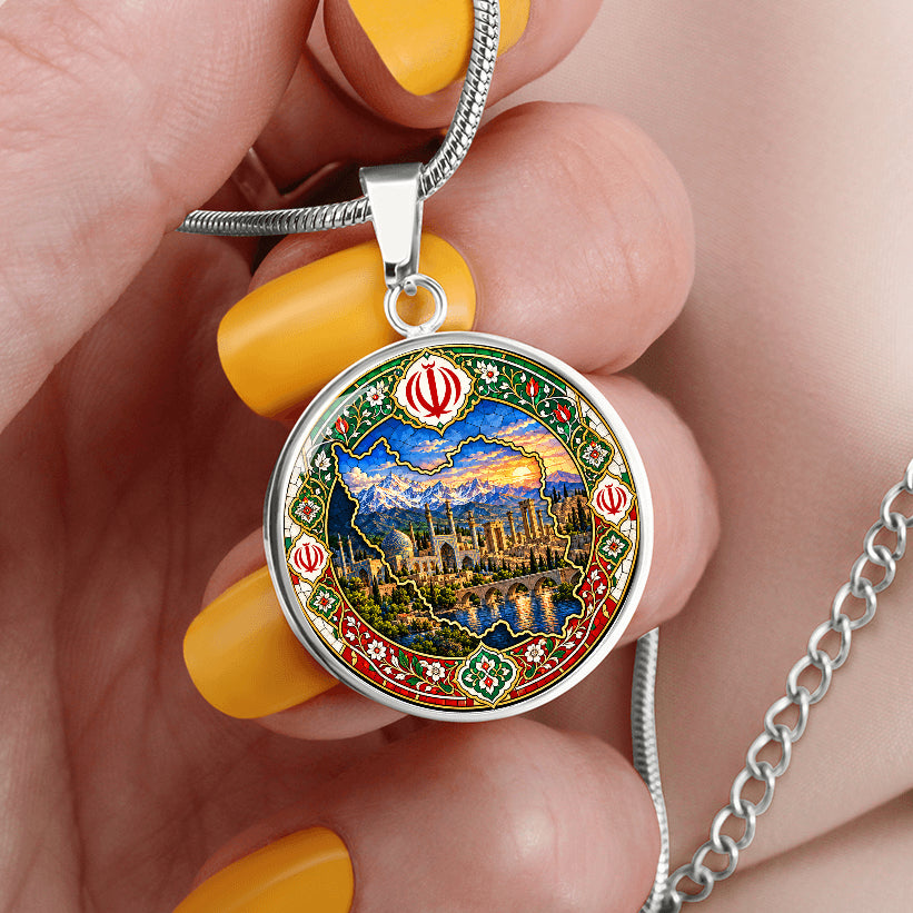 Silver Persian mosaic necklace held between fingers showing detailed Iran outline, mountains and ornamental floral artwork