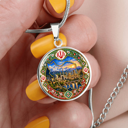 Silver Persian mosaic necklace held between fingers showing detailed Iran outline, mountains and ornamental floral artwork