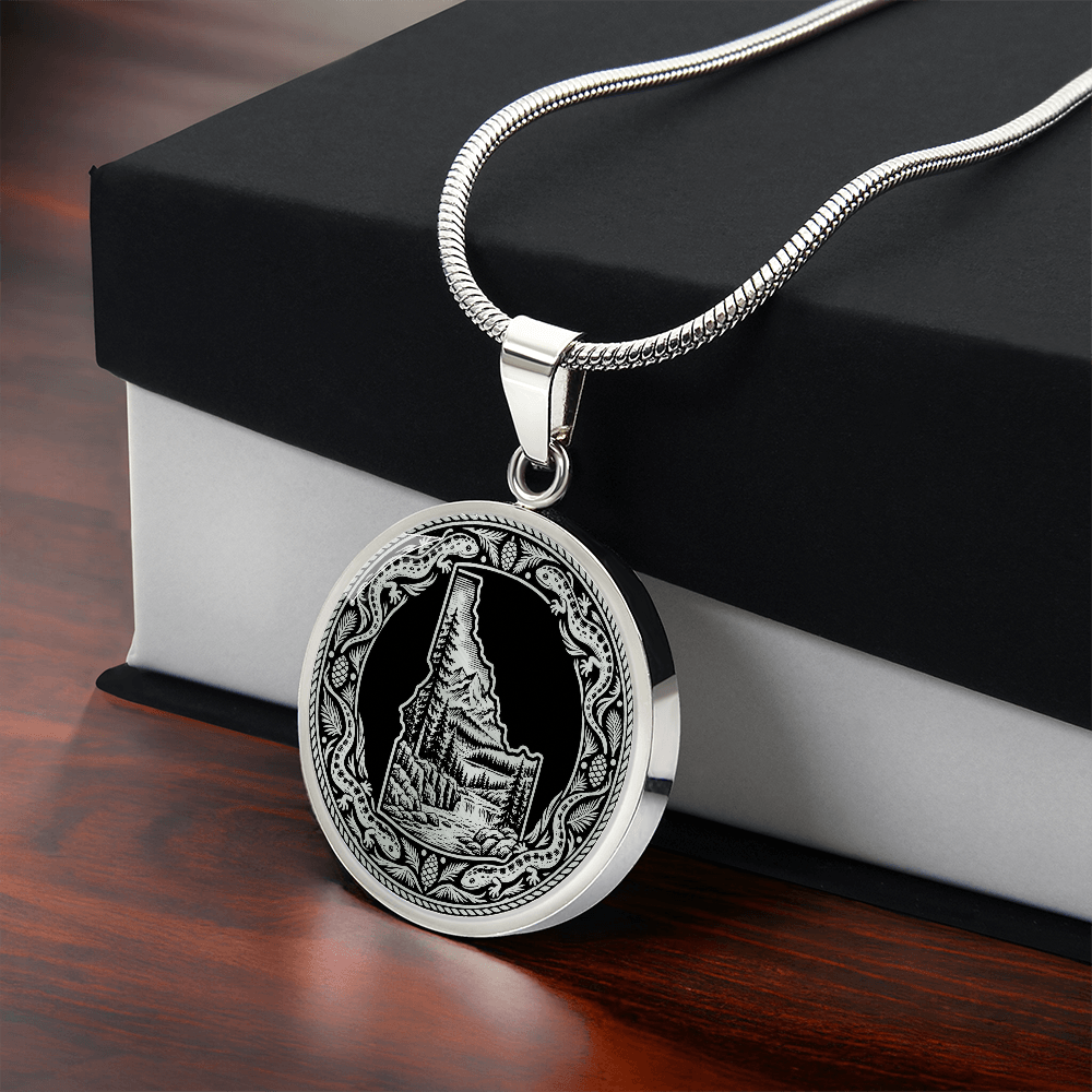 Silver Idaho wilderness necklace with Idaho state outline, mountain forest landscape, river and ornate salamander border with gift box