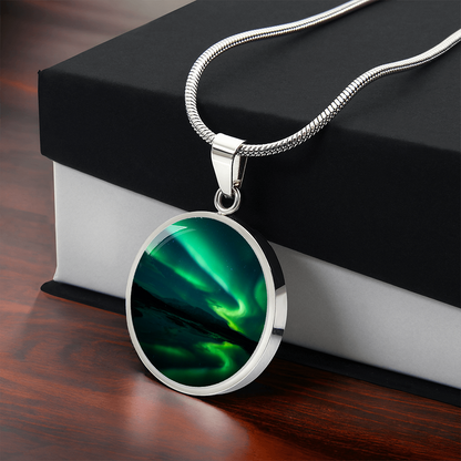 Green Aurora Northern Lights necklace featuring vivid emerald aurora ribbons above dark mountains on a round silver-colored pendant with free gift box
