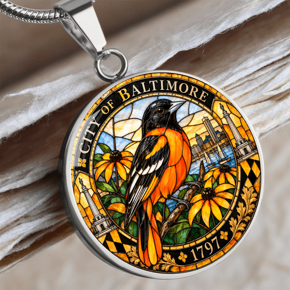 Close up of a Silver Baltimore Oriole necklace with orange and black stained-glass bird, golden flowers, City of Baltimore lettering and 1797 inscription