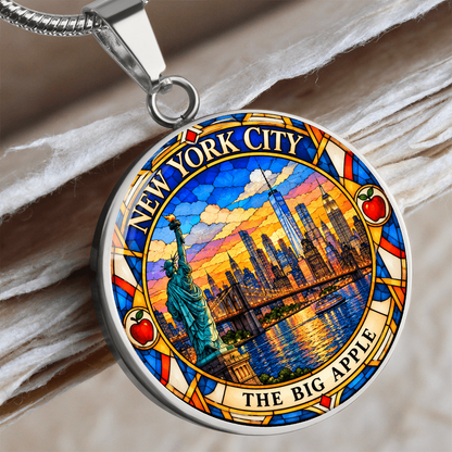 Close up of a New York City skyline necklace in silver finish with Manhattan skyscrapers, One World Trade Center, Brooklyn Bridge and colorful sunset