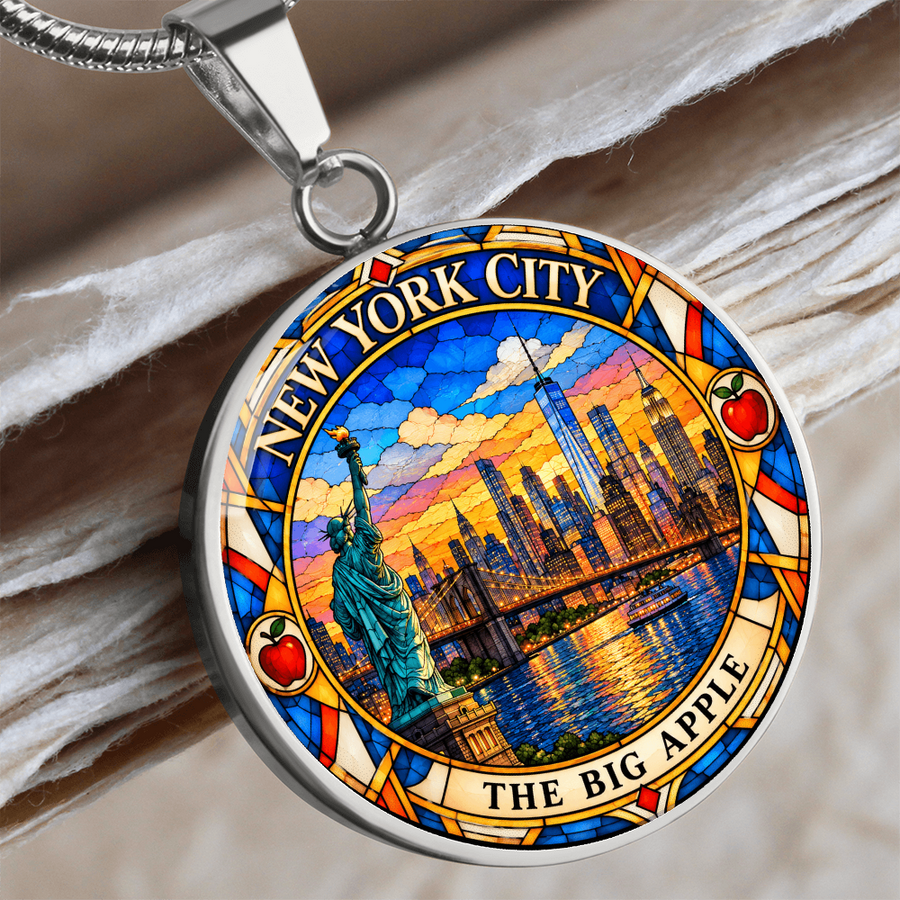 Silver New York City skyline necklace showing One World Trade Center, Manhattan skyscrapers, Brooklyn Bridge and colorful stained glass sunset
