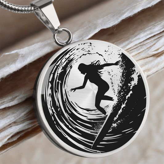 Female surfer necklace featuring a black silhouette of a woman riding inside a curling ocean wave on a round black-and-white pendant.