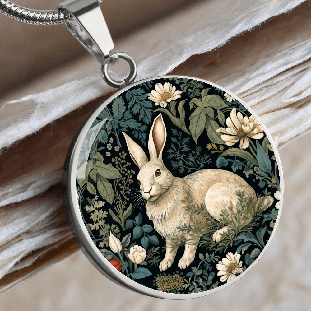 Silver Botanical rabbit necklace featuring a cream-colored bunny surrounded by ivory daisies and sage-green foliage on a dark round pendant.