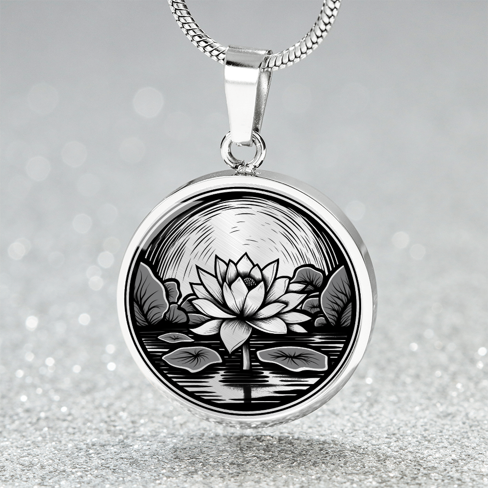 Lotus pond necklace with linocut-style artwork of a blooming lotus flower, aquatic leaves and water reflections on a round pendant.