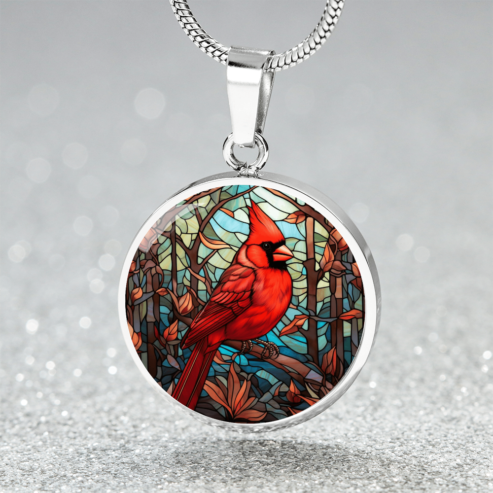 Stained glass-inspired cardinal necklace featuring a vivid red Northern Cardinal surrounded by colorful mosaic-style foliage on a round pendant. Silver