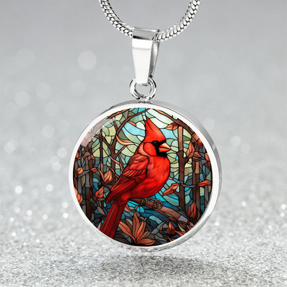 Stained glass-inspired cardinal necklace featuring a vivid red Northern Cardinal surrounded by colorful mosaic-style foliage on a round pendant. Silver