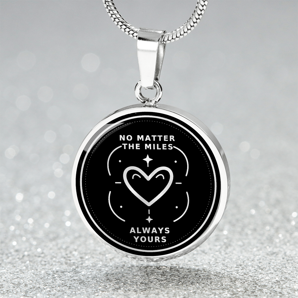 Close-up of silver long distance pendant with No Matter the Miles, Always Yours lettering and outlined heart surrounded by stars.