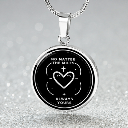 Close-up of silver long distance pendant with No Matter the Miles, Always Yours lettering and outlined heart surrounded by stars.