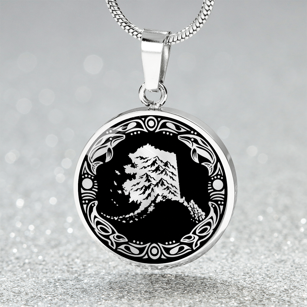 Silver Alaska mountain pendant necklace featuring snowy peaks, black and white linocut artwork and an ornate circular border. with sparklink mockup