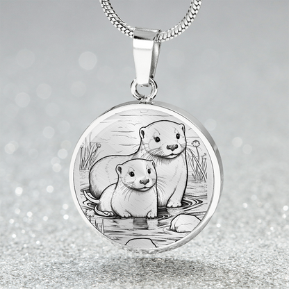 Sea Otter Couple Necklace featuring two otters together in a delicate black-and-white shoreline illustration on a silver-colored pendant.