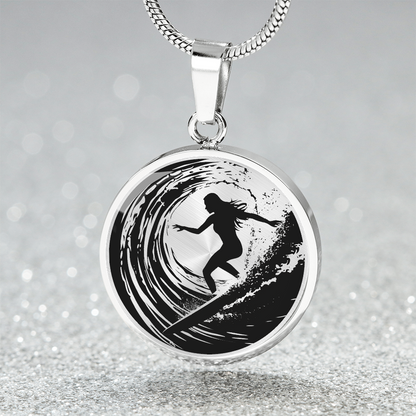 Silver Female surfer necklace featuring a black silhouette of a woman riding inside a curling ocean wave on a round black-and-white pendant.