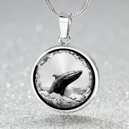 Breaching whale necklace with detailed black-and-white illustration of a whale rising from ocean waves on a silver-colored round pendant.