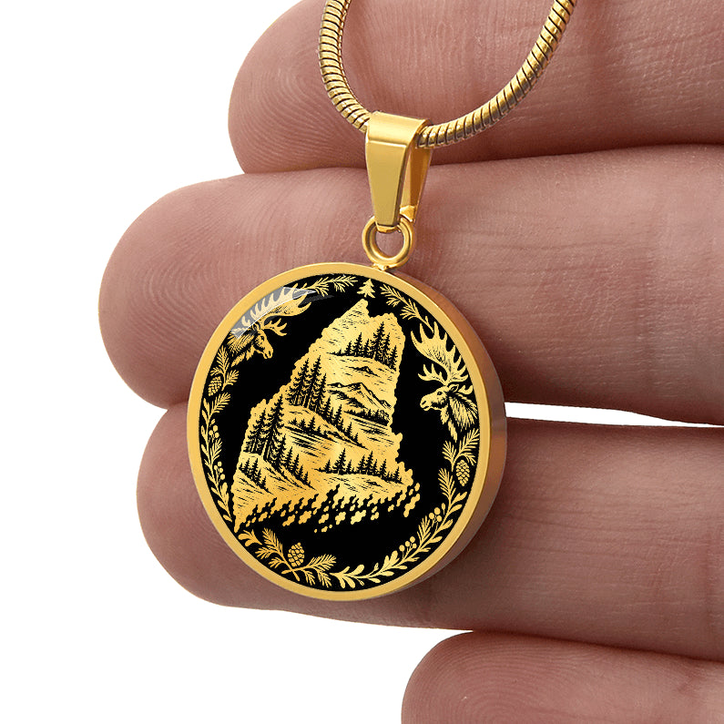 GoldMaine moose necklace featuring Maine state outline with mountain forest landscape, two moose and pinecone woodland border