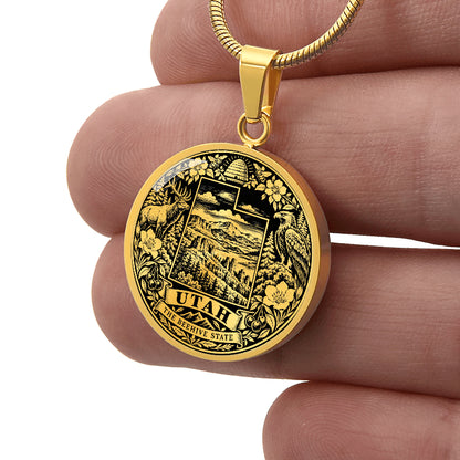 Gold finish Utah Beehive State pendant with stylized state outline, beehive, elk, eagle, mountain scenery and floral border