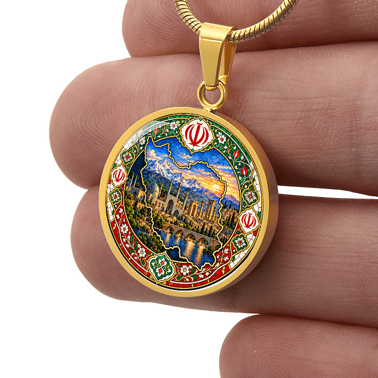 Gold finish Persian mosaic necklace held between fingers showing detailed Iran outline, mountains and ornamental floral artwork