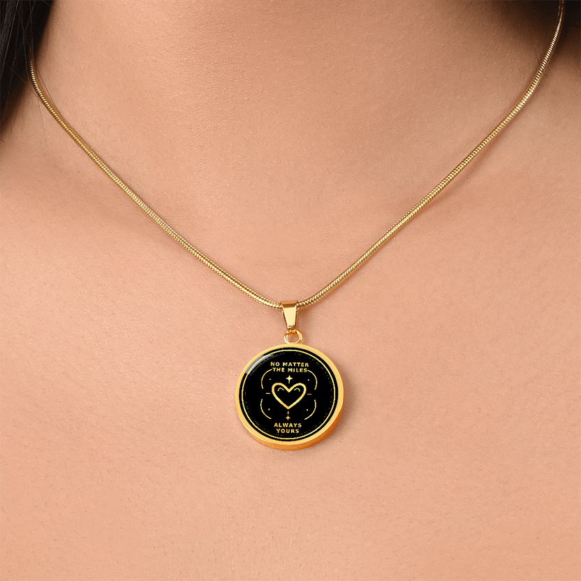 Gold finish No Matter the Miles pendant necklace worn at the neckline with black and gold heart message design