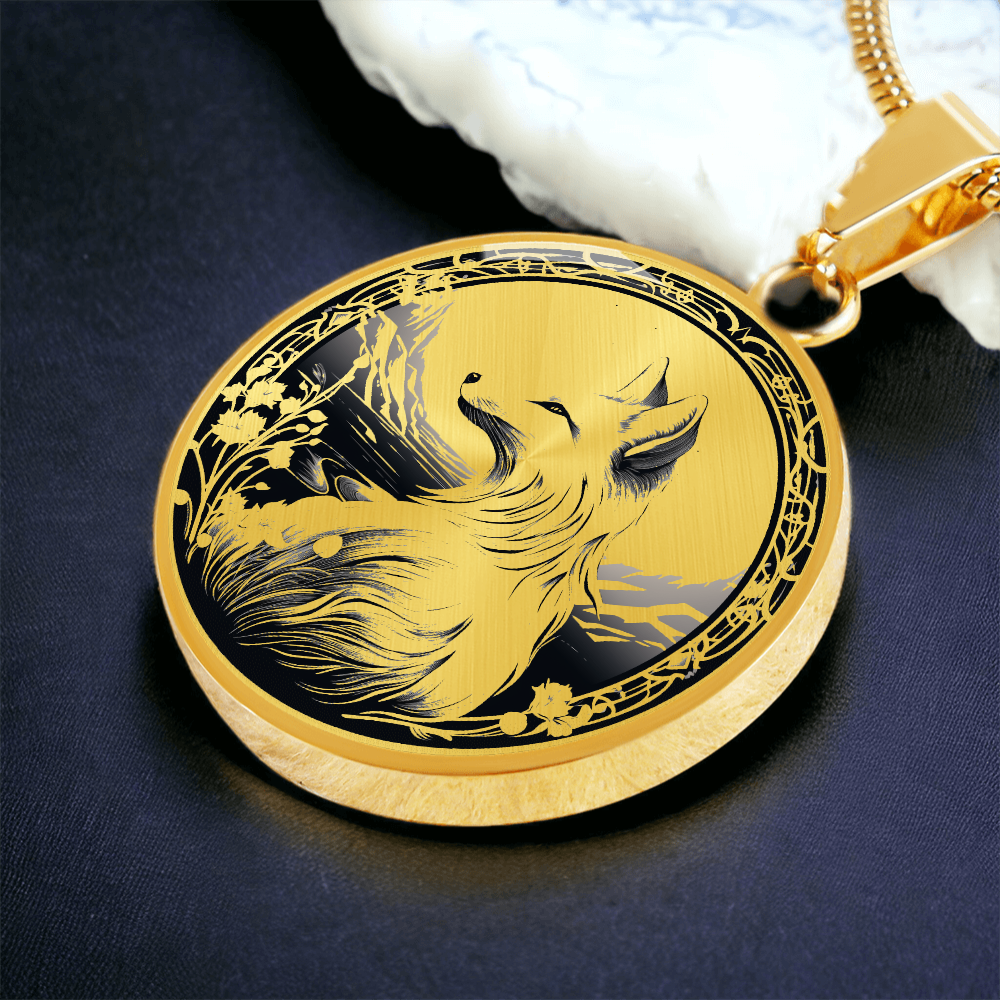 Gold Monochrome fox necklace featuring a seated fox with a bushy tail, distant mountains and decorative floral border on a round pendant, blue background