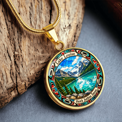 Gold finish Lake Louise pendant necklace showing bright blue mountain lake, snowy peaks, pine trees and decorative stained-glass artwork Woodbark mockup.