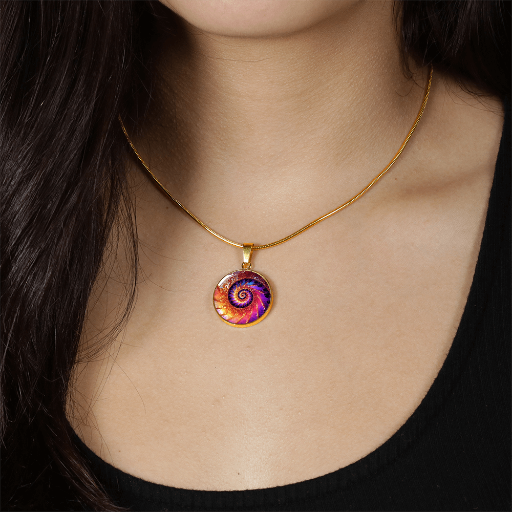 woman wearing a Fibonacci spiral necklace with vivid purple, orange and gold fractal-inspired spiral artwork on a round silver-colored pendant.
