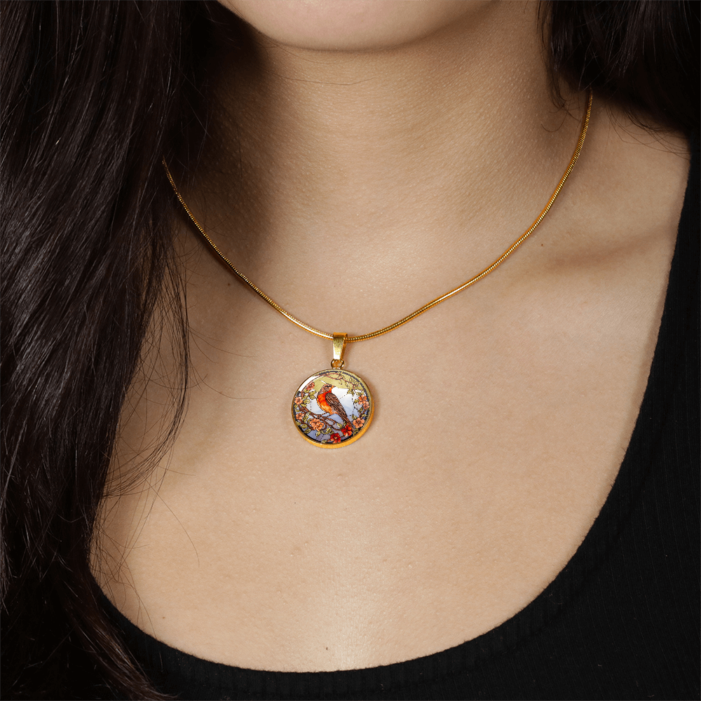 woman wearing a Stained-glass-inspired robin necklace featuring an orange-breasted bird perched among peach and red flowers on a round pendant.