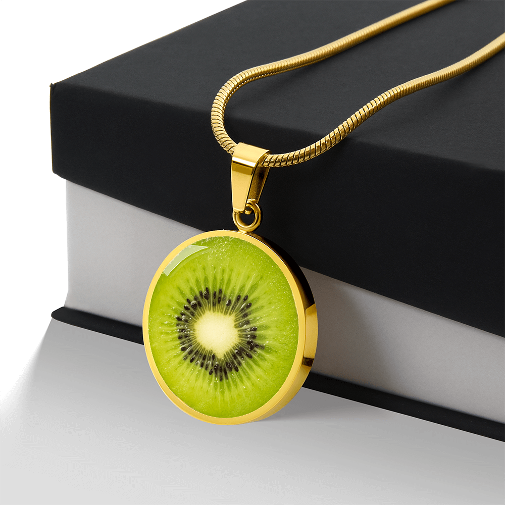 Kiwi fruit necklace featuring a vivid green kiwi slice with black seeds and pale center on a round silver-colored pendant with gift box
