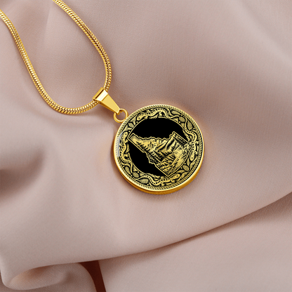 Gold finish Idaho state necklace featuring a black and white mountain wilderness illustration and decorative salamander-inspired frame